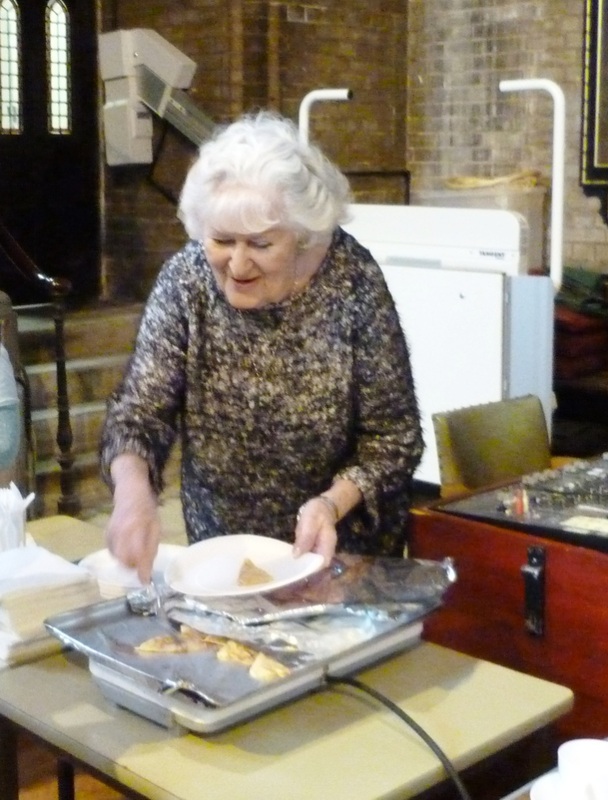A church volunteer serves pancakes on the Sunday before Lent.